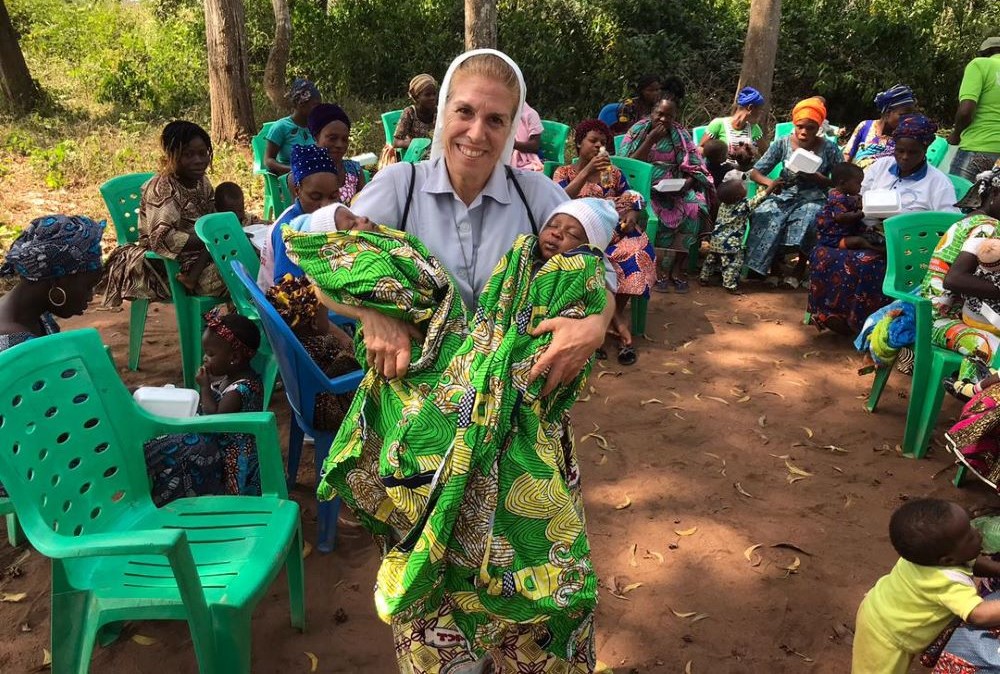 Sr. Monique Bourget holds healthy twins in Benin.