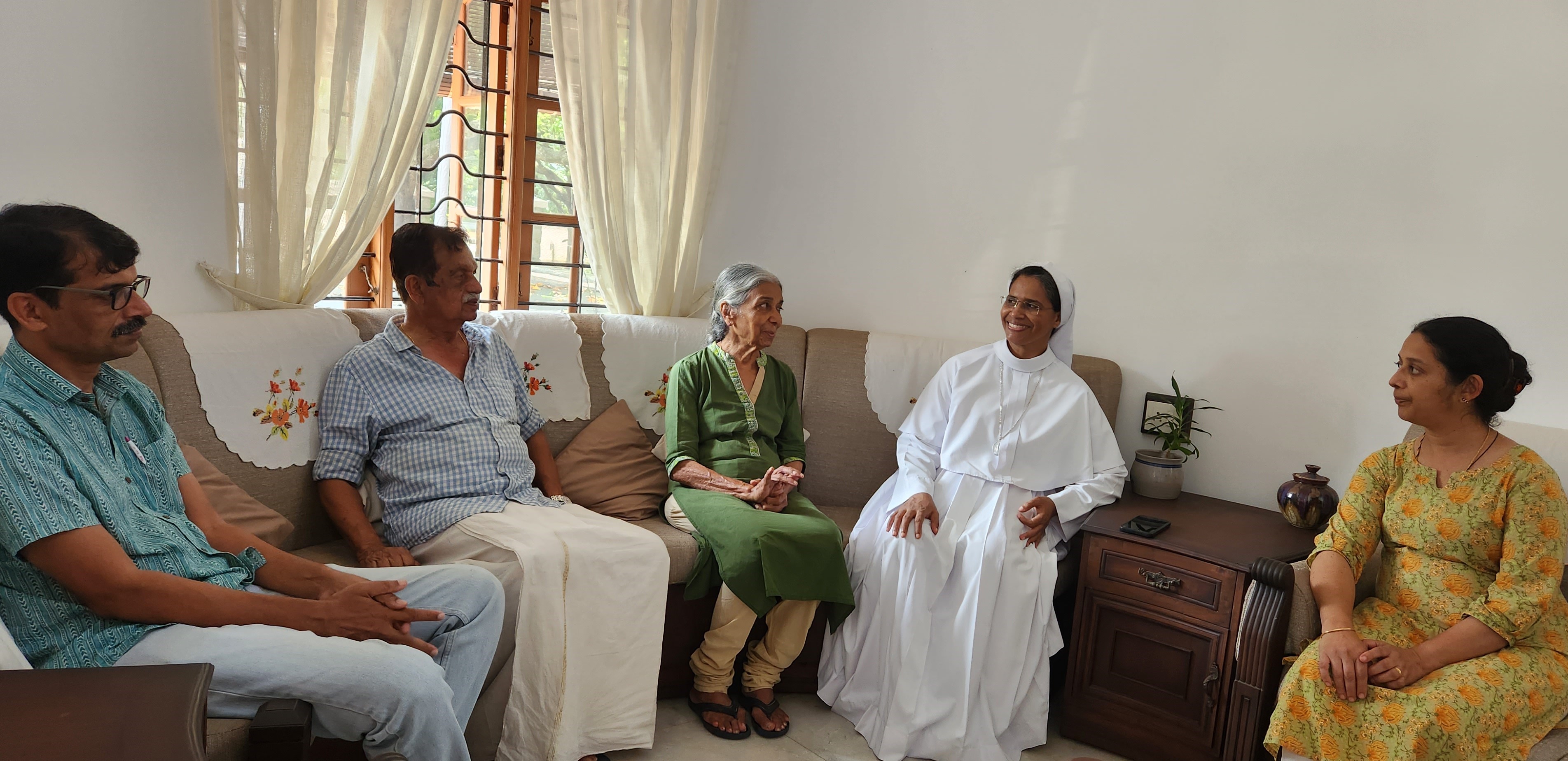 Sr. Delna Rose of the Missionary Sisters of Mary Immaculate speaks with the family of Kainady Jacob George during a home mission visit.