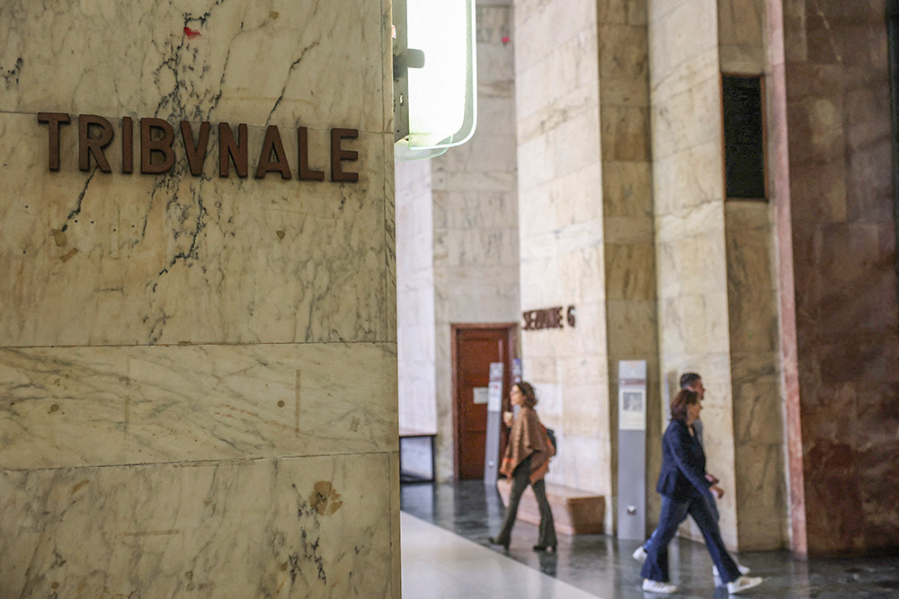 A sign displays the tribunal court location, as people walk along a corridor at Milan Court of Justice, Italy, April 26, 2024. A Sister of Charity in northern Italy was placed under house arrest after a nearly four-month investigation by prosecutors revealed she allegedly used her prison ministry to connect local mafia bosses with inmates. (OSV News/Reuters/Claudia Greco)