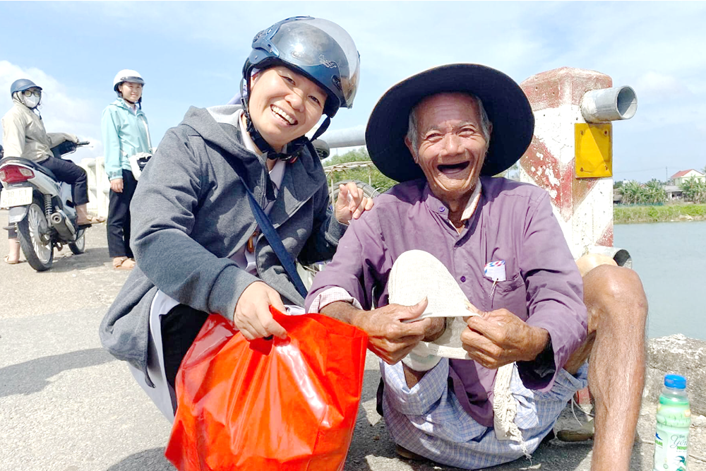 Daughters of Mary of Immaculate Conception Sr. Mary Anne Duong Thi Nhi offers cash and food to homeless Tran Anh Tuan in Thua Thien Hue province on Dec. 7. (Joachim Pham)