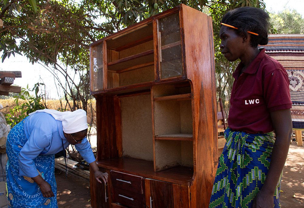 Sr. Catherine Mpolokoso inspects some of the furniture made by Eneles Phiri for sale in Livingstone. (Derrick Silimina)