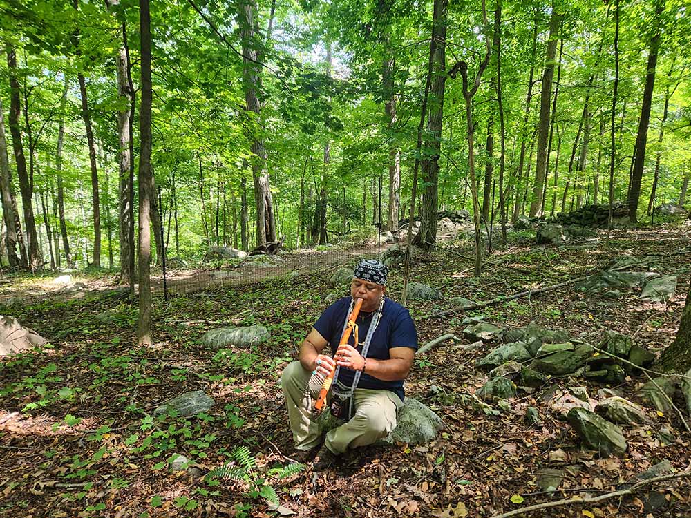 During a visit to the Hudson River Valley in late August, on what was once ancestral land, Shawn Stevens, a member of the Stockbridge-Munsee Community Band of Mohican Indians in Wisconsin, played a flute to honor ancestors. The Aug. 30 outing was spent in the Buttonhook Forest property in Chappaqua, New York. The visit was shepherded by the Dominican Sisters of Hope, whose sponsored ministry, the Center at Mariandale, hosted the visitors. (GSR photo/Chris Herlinger)