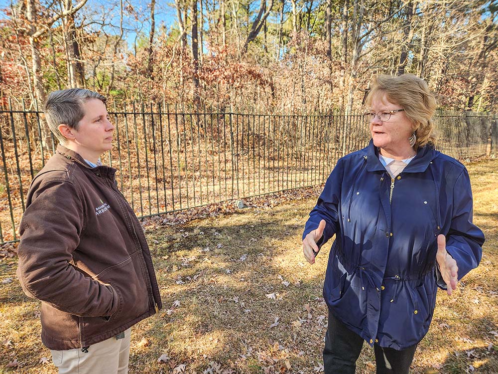 Heather Coste, the director of environmental sustainability for the Sisters of St. Joseph, Brentwood, New York, left, is joined by Sr. Karen Burke at the reburial site of remains of members of Shinnecock Indian Nation on Long Island at the congregation's cemetery. (GSR photo/Chris Herlinger)