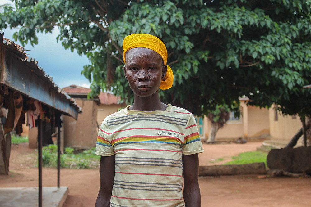 Naanzem Bayawaa, now 20, in front of her parent’s house. She gave birth to her first child at 12 and her second at 15. (GSR photo/Valentine Benjamin)