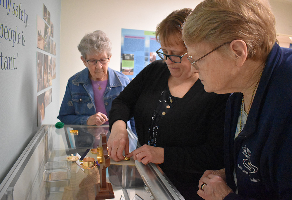 Srs. of Notre Dame de Namur Judith Clemens, left, Teresa Phillips, center, and Kathleen Harmon, right, prepare the reliquary with the soil soaked with Stang's blood. Phillips and Harmon will transport it to Rome in January for the ceremony at the Basilica di San Bartolomeo all'Isola. (Courtesy of Sisters of Notre Dame de Namur Ohio Province)