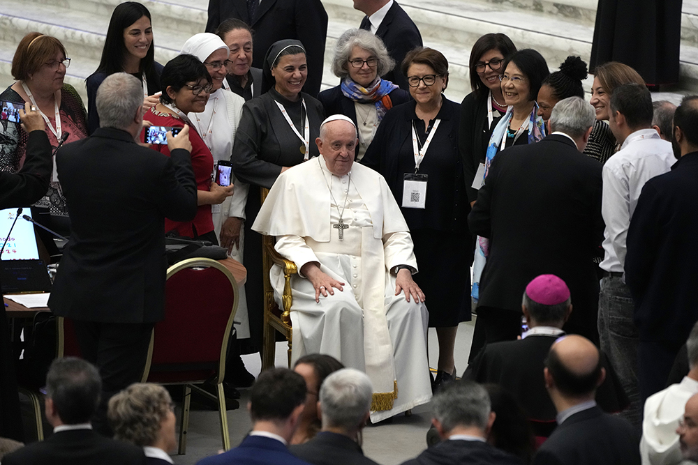 Pope Francis poses with a group of women before a session of the 16th general assembly of the synod of bishops in the Paul VI Hall at The Vatican, Oct. 28, 2023. The seventh from left is Sr. Nathalie Becquart, undersecretary in the Vatican's Synod of Bishops. (AP/Alessandra Tarantino)