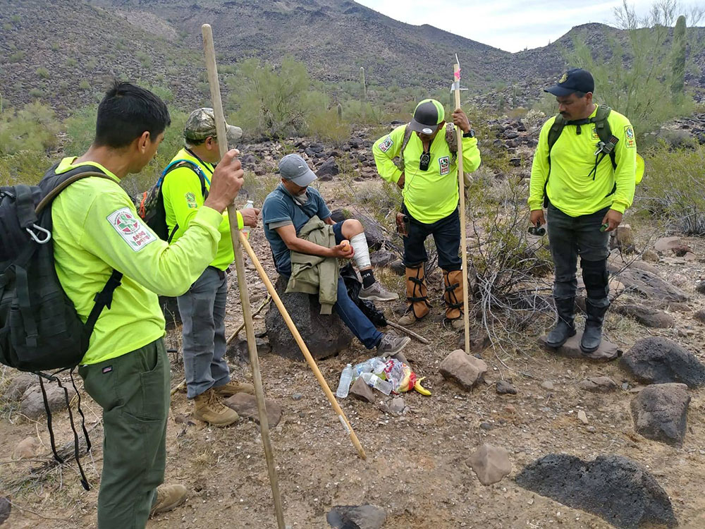 Volunteers from Aguilas del Desierto, a search and rescue organization, help an injured man they rescued in the desert as he was attempting to cross the southern border into the United States. (Courtesy of Aguilas del Desierto)