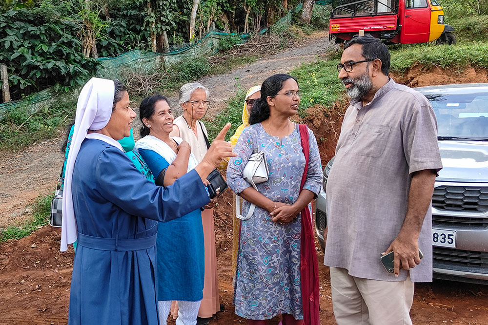 Sr. Lucia Paravananickal (left) of the Sisters of Charity of St. Vincent De Paul and Providence of Gap Sr. Mary Philip (third from left) interact with Claretian Fr. George Kannanthanam during the house handing-over ceremony at Chooralmala in the Wayanad district of Kerala, southwestern Indian state. (Thomas Scaria)