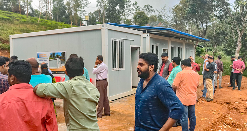 Beneficiaries gather around the temporary houses being handed over to the landslide victims of Wayanad in the southwestern Indian state of Kerala. (Thomas Scaria)