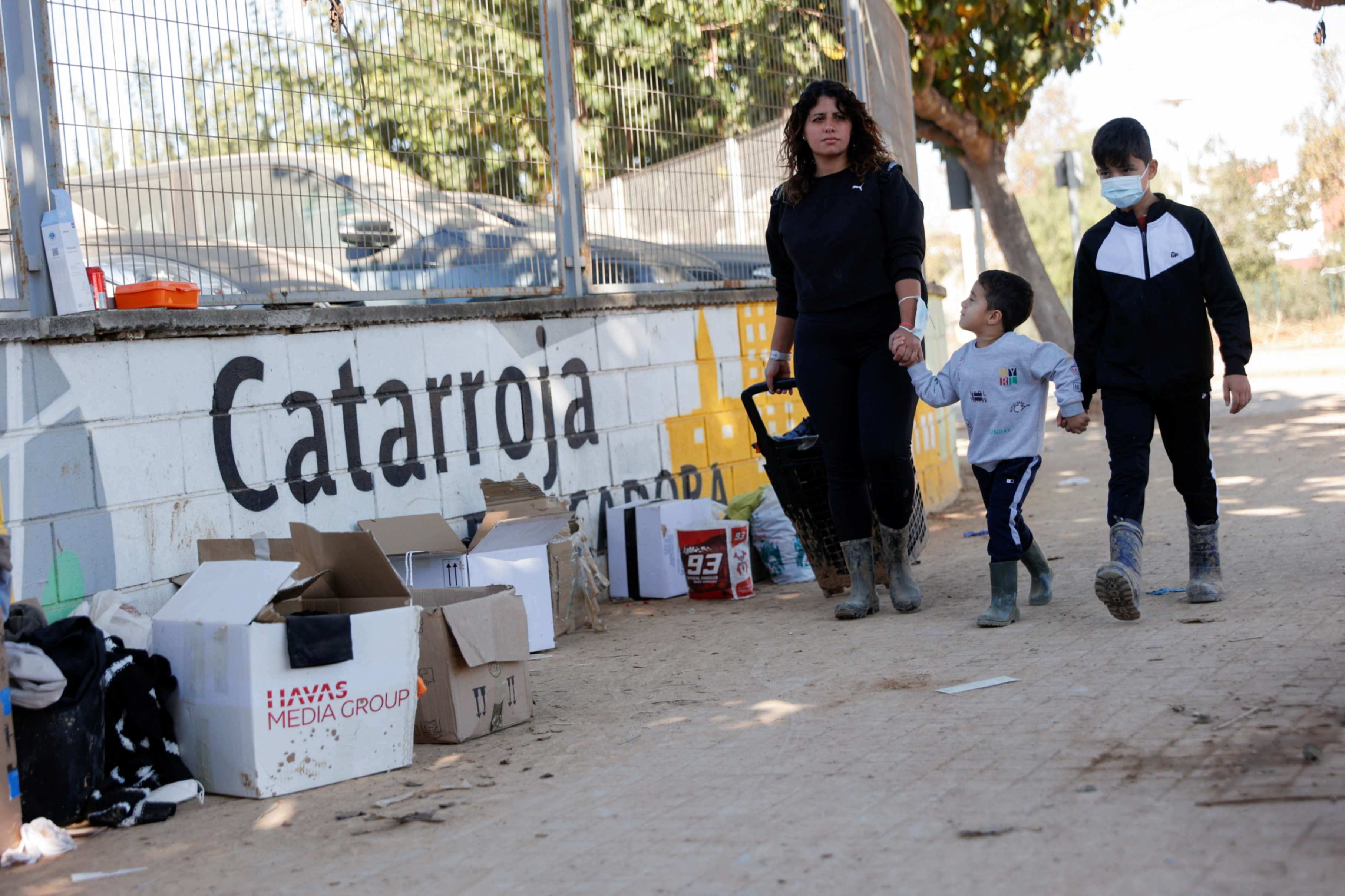 A woman walks with her children along a street in the town of Catarroja, in Valencia, Spain, on Nov. 11, 2024, as they look for a church to provide them with cleaning products following heavy rains that caused deadly flooding in late October. (OSV News/Reuters/Eva Máñez)