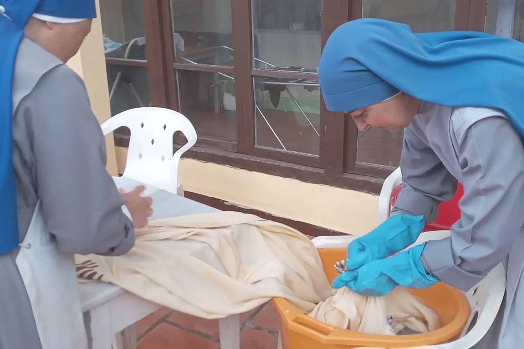 Contemplative sisters of the Religious Family of the Incarnate Word wash liturgical ornaments swept away by the rains. (Courtesy of Religious Family of the Incarnate Word)