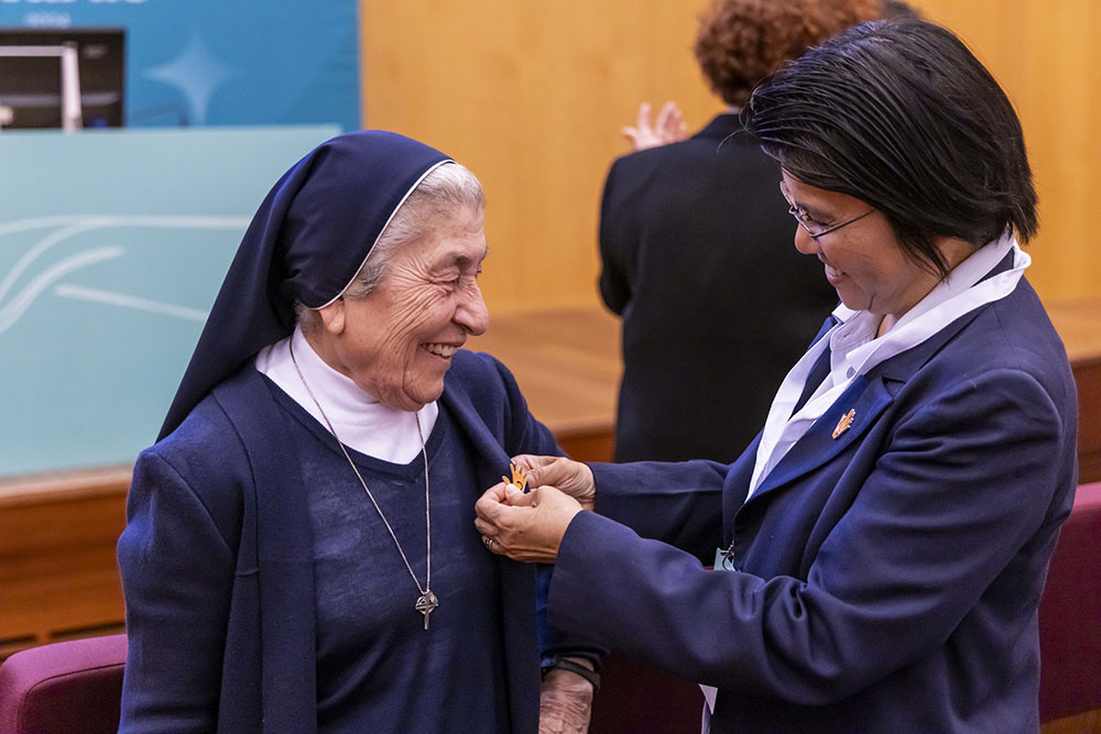 Sr. Abby Avelino, Talitha Kum international coordinator, pinning the official logo of Talitha Kum to Sr. Marie Claude Naddaf, identifying her as a Talitha Kum anti-trafficking advocate. (Stefano Dal Pozzuolo)