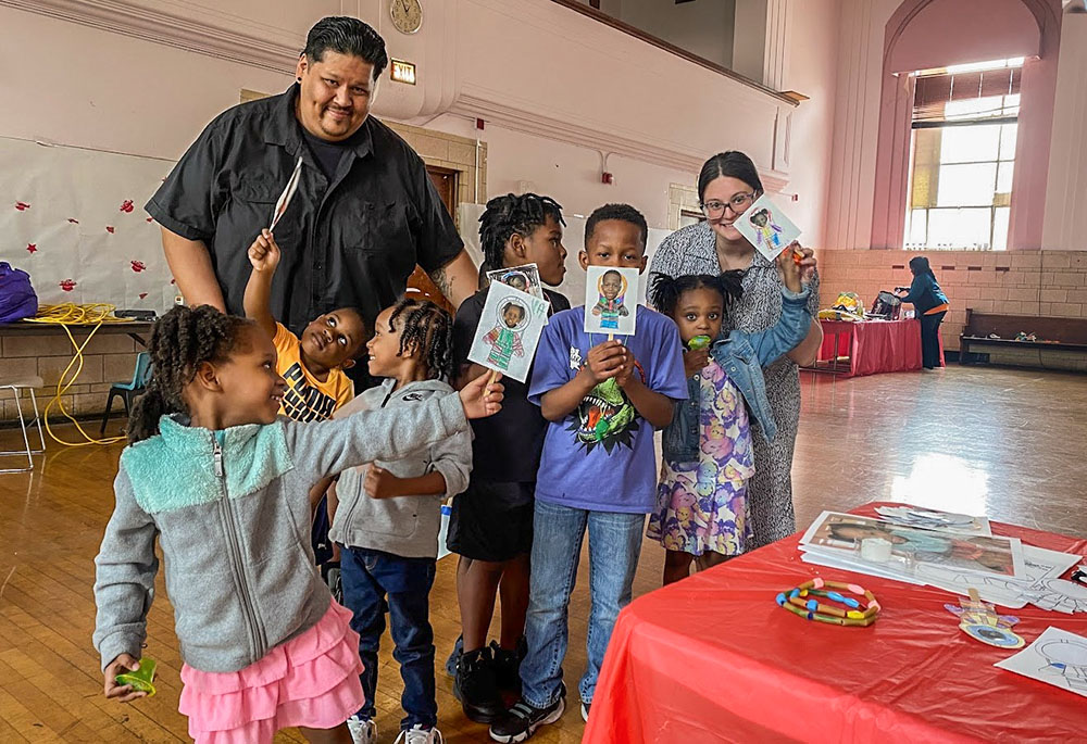 United Stand staff members Guillermo Rodriguez and Monica Kaczmarczyk pose with Chicago children displaying artwork they created at one of the nonprofit’s programs. (Courtesy of United Stand)