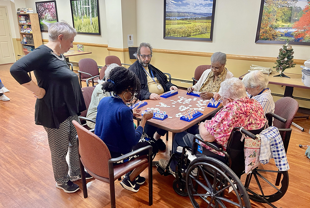 At right, Sr. Cecilia Palange, 99, a retired nun and resident at Kittay New Jewish Home since 2016, plays boardgames with residents from other cultural and religious traditions on Dec. 13, 2024. (NCR photo/Camillo Barone)