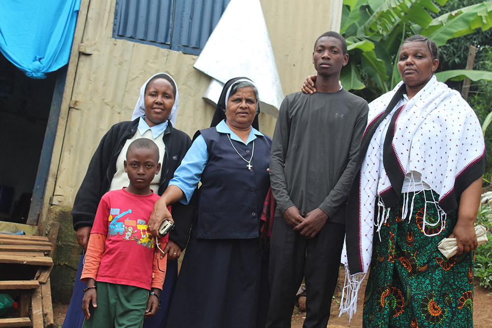 Paulina Masawe (right), who was pressured by her husband to relinquish her children to traffickers, and Stanley Joakim stand with Catholic sisters and Stanley's younger brother in Arusha, Tanzania. Masawe and Stanley were helped by the sisters after becoming victims of human traffickers. (GSR photo/Doreen Ajiambo)