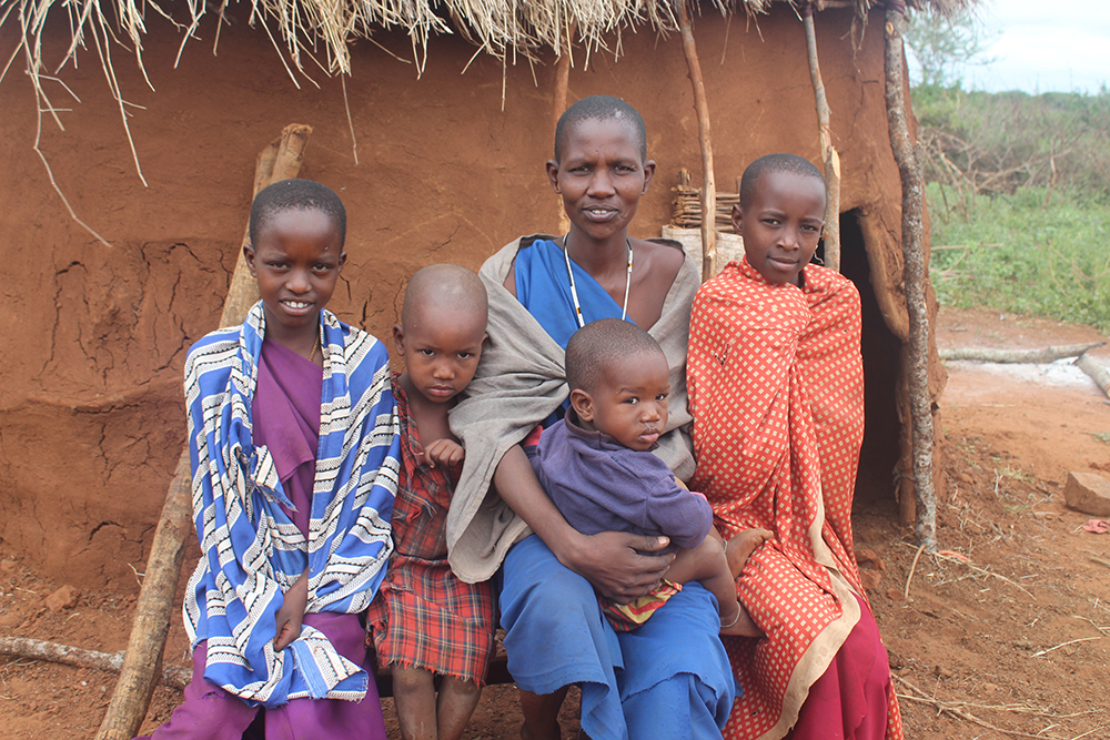 A majority of families in northern Tanzania are vigilant about protecting their children from trafficking risks. Here, a woman sits outside her hut with her children in June 2019. (GSR photo/Doreen Ajiambo)