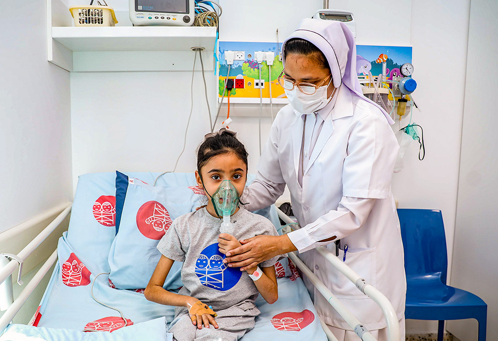 Charity Sr. Bency Paul helps a young patient at Caritas Baby Hospital Bethlehem in the West Bank. (Courtesy of Caritas Baby Hospital/Andreh Ghawaly)