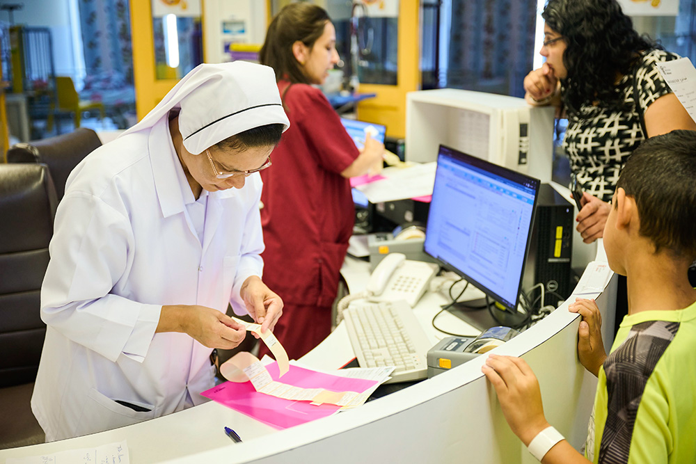 Charity Sr. Bency Paul helps check in patients at Caritas Baby Hospital Bethlehem in the West Bank. (Courtesy of Caritas Baby Hospital/Meinrad Schade)