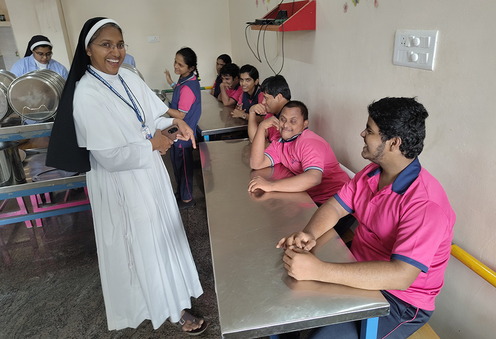 Franciscan Clarist Sr. Mareena Mathew is pictured with the children in the dining hall of Navajeevana in Bedrampalla, Kasaragod District, Kerala, as they wait for lunch. (George Kommattam)