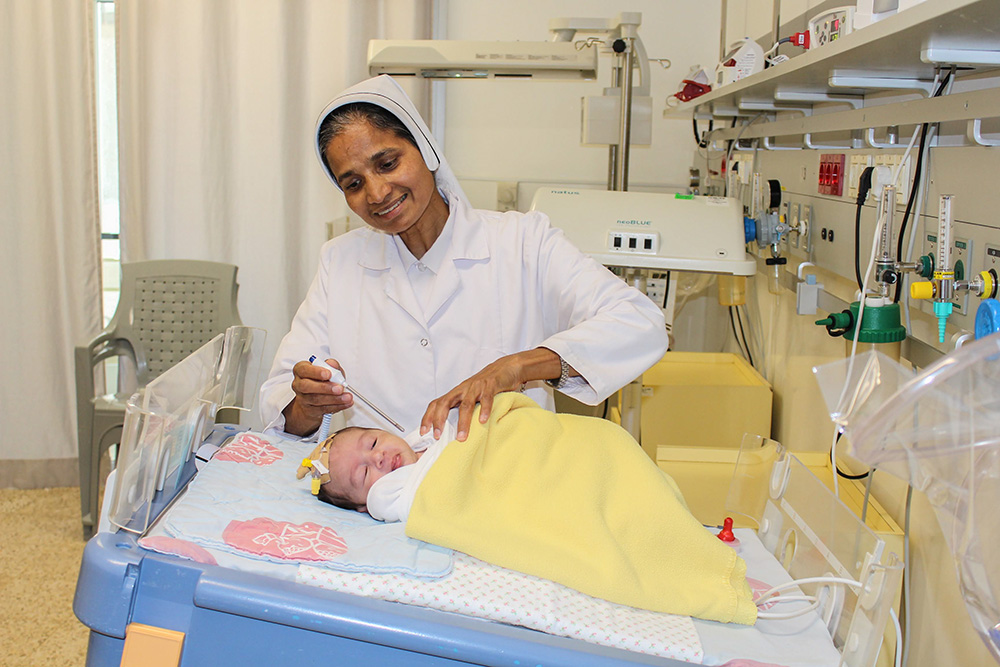 Charity Sr. Theresia Crasta checks the temperature of a patient at Caritas Baby Hospital Bethlehem in the West Bank. (Courtesy of Caritas Baby Hospital/Marian Nasser)