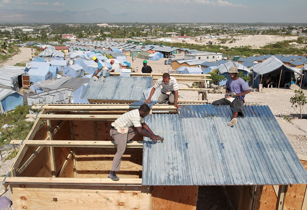 Workers at a camp in Terrain Toto, Haiti, construct transitional shelters provided by Catholic Relief Services for those left homeless in the 2010 earthquake. Catholic Relief Services was among the humanitarian entities deeply affected by USAID cuts. (OSV News/Bob Roller)