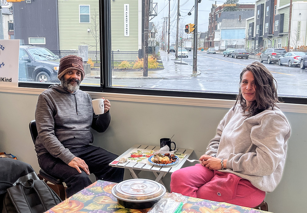 Guests Gregory Morton and Angela Rice sit in the front room of St. Joseph's Place in Schenectady, N.Y. "This is a safe haven," Morton said. "If they're open, I'm here." (Sara Foss)