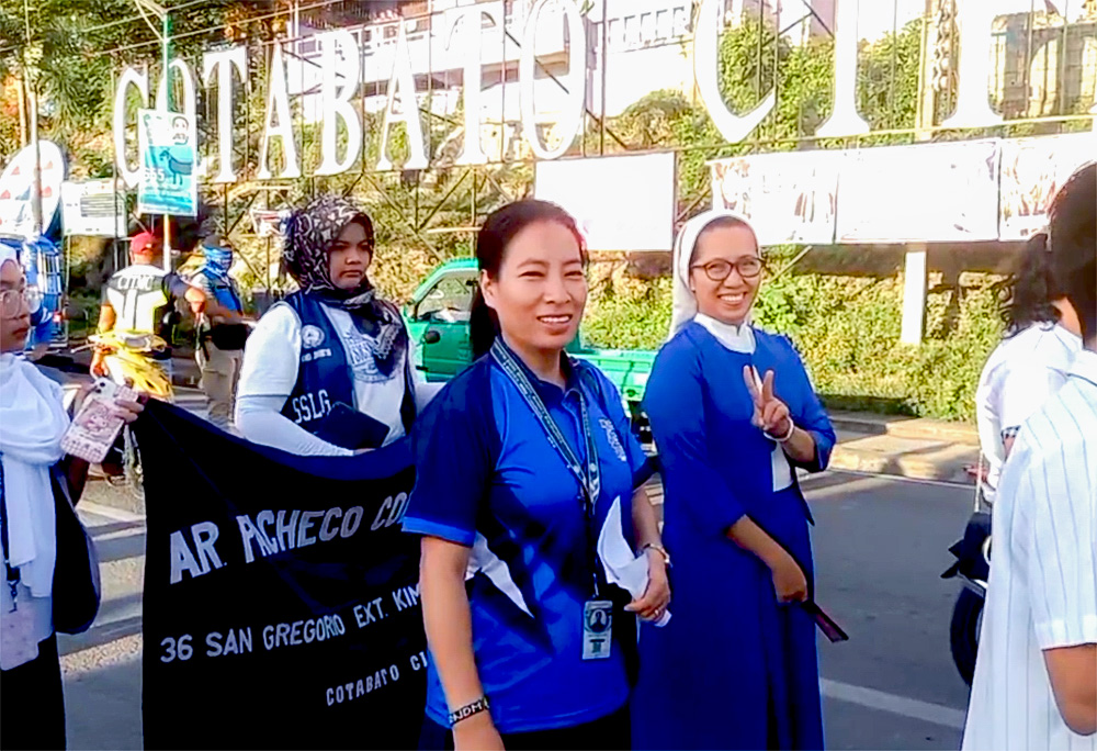 A Religious of Notre Dame of the Missions, left, and a Sister Oblate of Notre Dame, right, walk during the Mindanao Week of Peace celebration in Cotabato, the Philippines, usually observed in the last week of November and the first week of December. (Courtesy of Petite Lao)