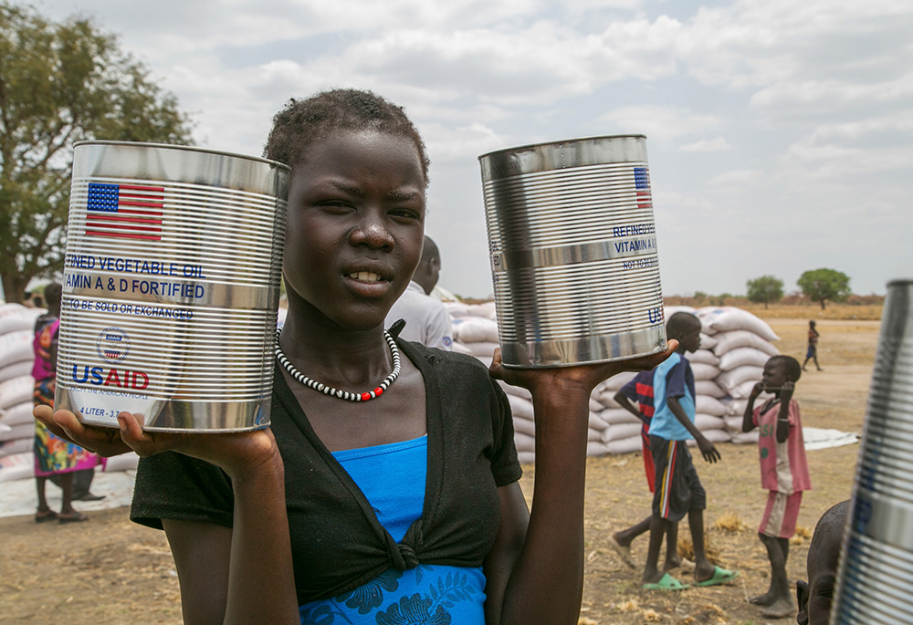 A woman holds cans of vegetable oil provided by U.S. Agency for International Development in Pajut, South Sudan, on March 17, 2017. (CNS//Catholic Relief Services/Nancy McNally)