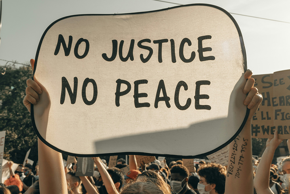 A sign that says "No Justice, No Peace" (Unsplash/Clay Banks)