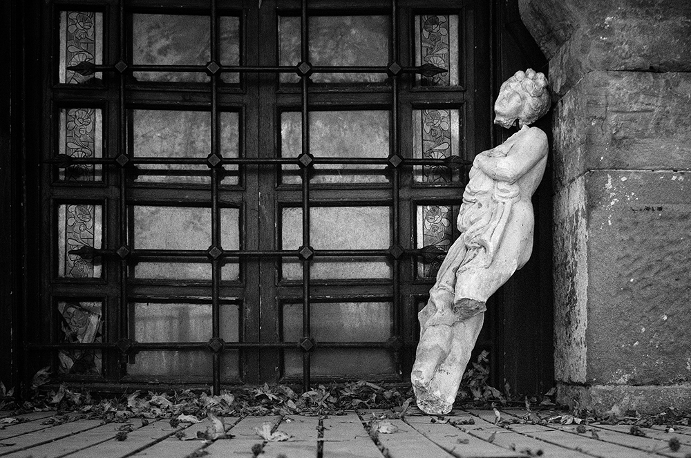 A broken statue sitting against a wall (Unsplash/Dmitry)