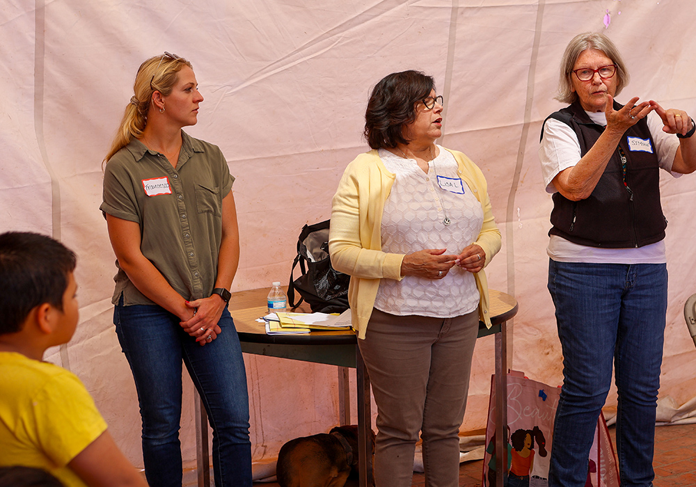 Sr. Simone Campbell (right) and Sr. Lisa Lopez (middle), both members of the Sisters of Social Service, give a presentation about immigration law with another volunteer to residents at the Cobina Posada del Migrante Shelter, one of many regular legal presentations arranged through Border Compassion.  (Courtesy of Border Compassion)