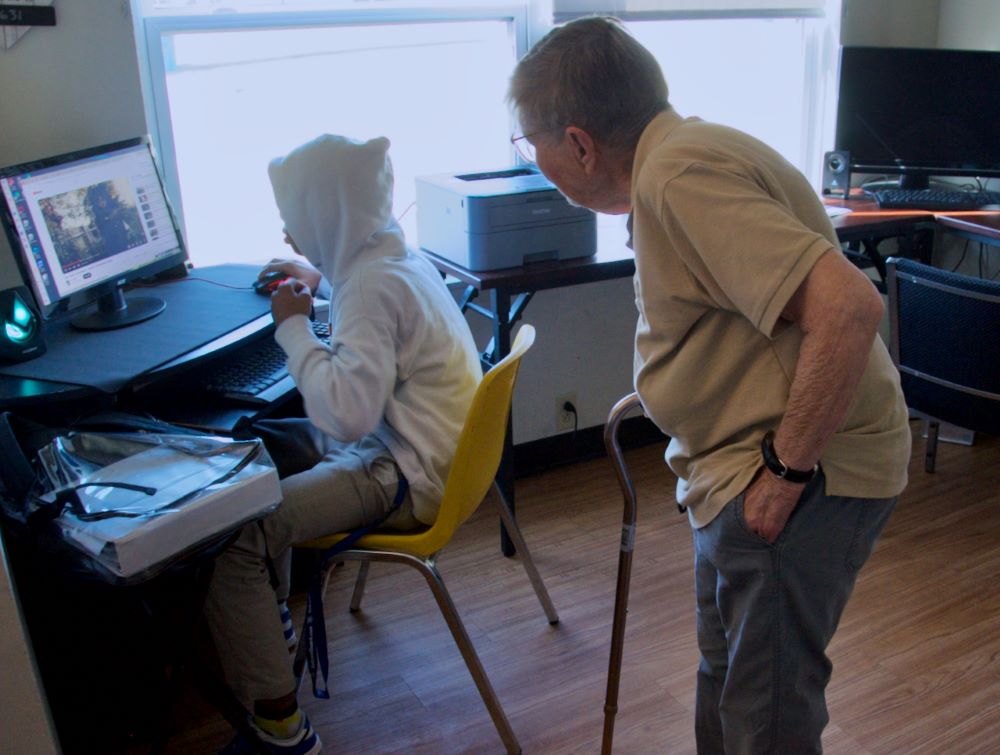 Sr. Julia Huiskamp helps a student use the computer. Sr. Julia Huiskamp helps a student use the computer.