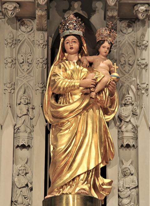 A prayer card for The National Votive Shrine of Our Lady of Prompt Succor shows Mary holding a child with both hands, with swishing garments to show she's in a hurry as she is packing up and boarding a boat. The statue was carved specifically for this shrine. (Courtesy of The National Votive Shrine of Our Lady of Prompt Succor)