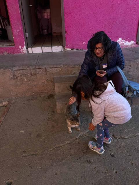 Social Service Sr. Elizabeth Lopez talks to a little girl while petting a cat at the Cobina Posada del Migrante shelter in Mexicali, Mexico, Feb. 8. Lopez, an immigration attorney, said her family’s commitment to social justice took her on a path to join the Social Service Sister focused on systemic change. (GSR photo/Rhina Guidos)