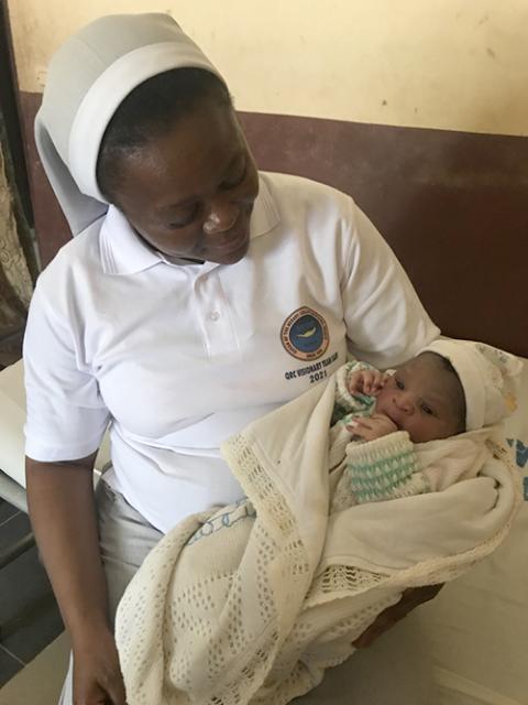 Sr. Rosemary Arrah holds the baby of a teenage mother in October 2022. (Rosemary Arrah) 