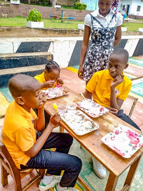 Students learn how to transfer water from one container to another using a spoon at the Community Based Rehabilitation Center in Akure, Ondo state, Nigeria. The exercise helps with hand-eye coordination. (Courtesy of Christie Udebor)