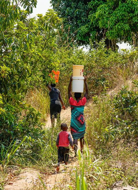 Girls return from the stream with their filled buckets of water at Mphatso village, Malawi, on Oct. 1, 2021. (Courtesy of Monica Ichife)