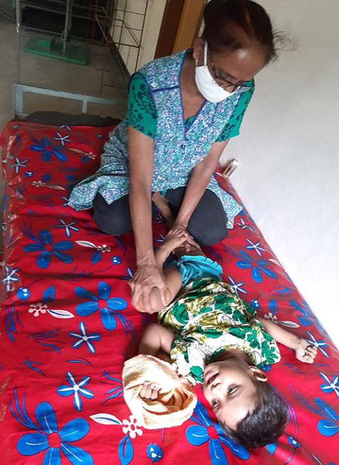 Sr. Nirmola Maria Goretti Cruze provides physiotherapy to a child at the Hope Center in Tejgaon, Dhaka. (Sumon Corraya)