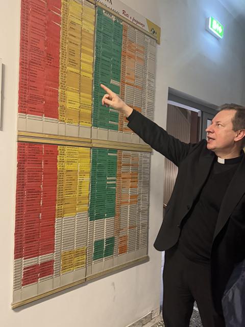 Fr. Paweł Rytel-Andrianik points to the board showing the stations and transmission times in different languages for Vatican Radio Jan. 22, 2025. (Helga Leija)