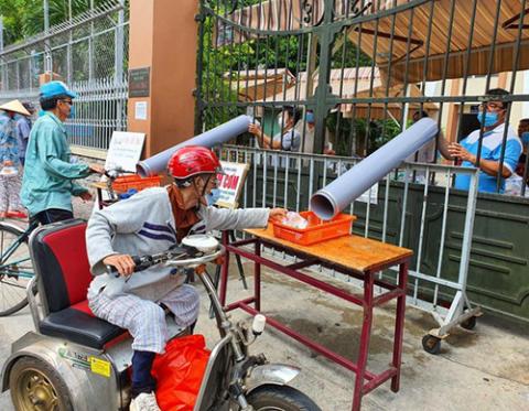 Members of the Caritas charity committee of Thu Duc parish in the Archdiocese of Ho Chi Minh City in Vietnam provide breakfast to workers in need. At the parish gates, these gifts are transferred via a water pipe. (Mary Nguyen Thi Phuong Lan)