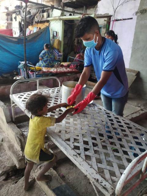 A street boy, now working as a COVID-19 warrior, reaches out in service. (Courtesy of Teresa Joseph)