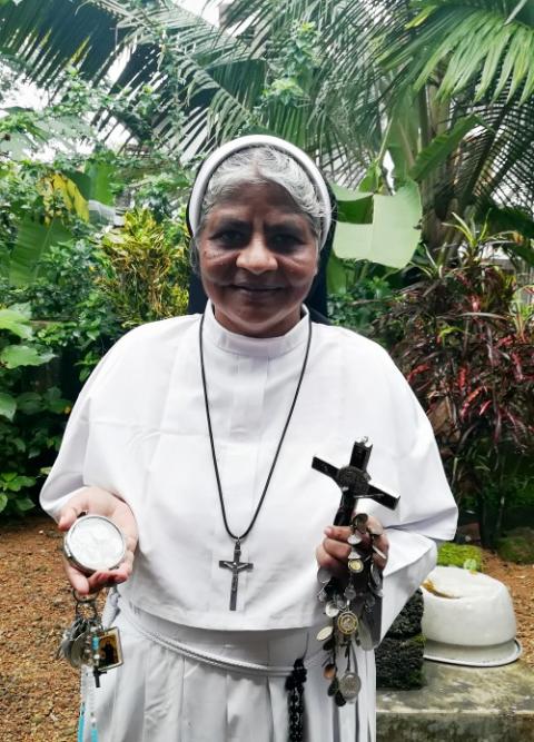 Franciscan Clarist Sr. Lissy Vadakkel, a key witness in the rape case against Bishop Franco Mulakkal, displays lockets of saints, a rosary, religious relics and a crucifix engraved with "Missionaries of Jesus," the congregation of the rape survivor.