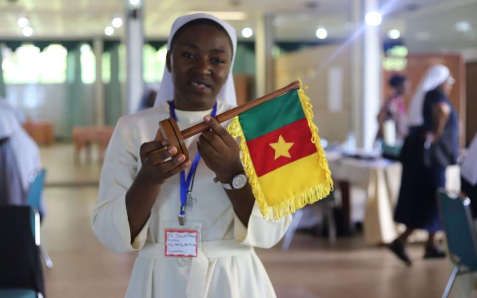 Sr. Janefrancis Kinyuy, a member of the Daughters of the Holy Family of Bafoussam, holds the flag of Cameroon during the All-Africa Conference: Sister to Sister convening in Entebbe, Uganda, April 10.