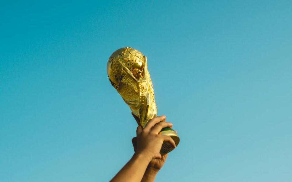 hands holding up a gold trophy