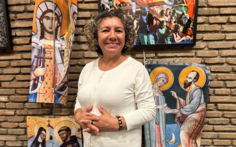 Rosa Bonilla stands near a banner representing St. Phoebe with St. Paul the Apostle at San Lorenzo chapel at the Centro Internazionale Giovanile in Rome Oct. 3.