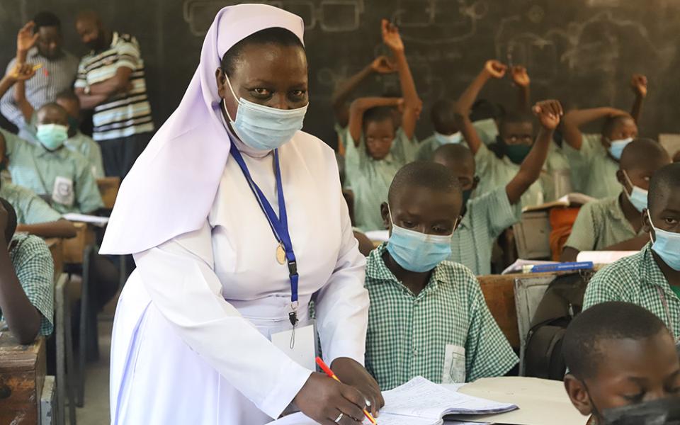 Sr. Anne Onyancha helps a boy with his studies at St. Peter's Mumias Boys Primary School in Kakamega, Kenya. (GSR photo/Doreen Ajiambo)