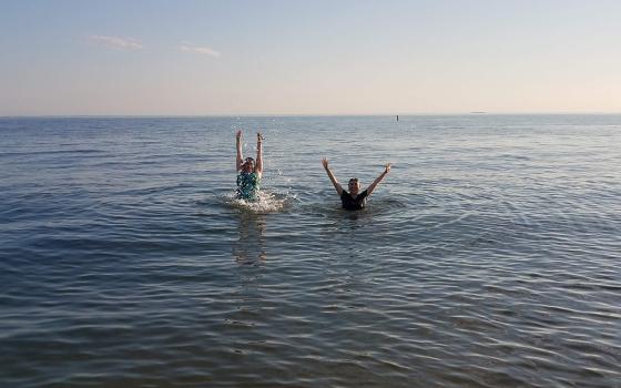 Dominican of Peace Sr. Ana Gonzalez, left, and Lovers of the Holy Cross Sr. AnHoa Nguyen enjoy the water of the Long Island Sound at Hammonasset Beach State Park in Madison, Connecticut, in summer 2020. (Provided photo)