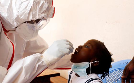 A health care worker takes a swab from a child during a mass testing May 26 in Nairobi, Kenya, during the COVID-19 pandemic. (CNS/Baz Ratner, Reuters)