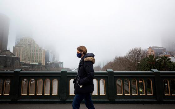 A person in a protective face mask walks along the Princes Bridge in Melbourne, Australia, July 17, 2020, during a lockdown in response to the coronavirus pandemic. (CNS/Reuters/Daniel Pockett)