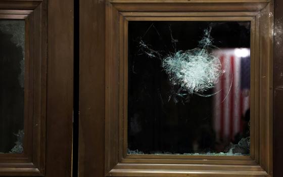 A broken window is seen in the U.S. Capitol during a joint session of Congress in Washington Jan. 7 after lawmakers reconvened to certify the Electoral College votes of the 2020 presidential election. (CNS/Reuters/Jonathan Ernst)